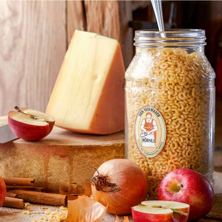 Zutaten wie Apfel, Käse, Zwiebel und Hörnli die für die Appenzeller Chäshörnli benötigt werden.