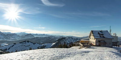 Restaurant in den Bergen mit Sonnenschein und Schnee